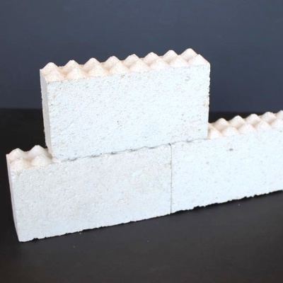 Três blocos de construção brancos com topo ondulado sobre superfície preta