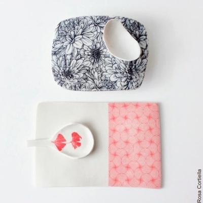 Conjunto de loiça com padrões florais e geométricos em preto, branco e vermelho.