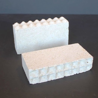 Duas peças retangulares brancas com texturas diferentes sobre superfície escura