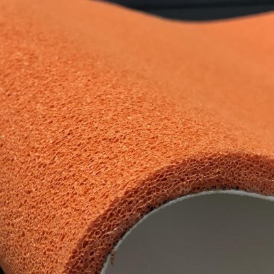 Rolo de material esponjoso laranja com textura porosa