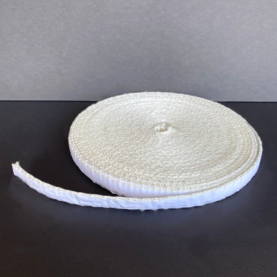 Rolo de fita branca trançada sobre superfície preta