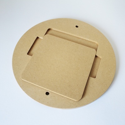 Peça circular de madeira com recortes quadrados e superfície lisa