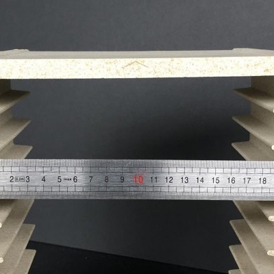 Peça clara com ranhuras laterais e régua de metal a medir largura