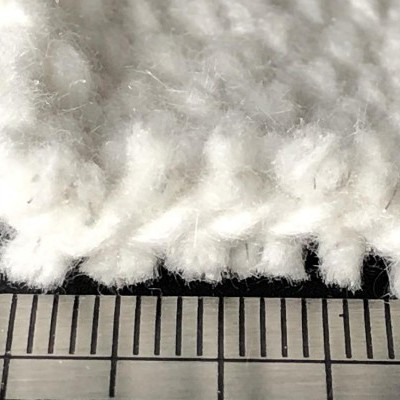 Tecido branco com textura felpuda e régua para medição