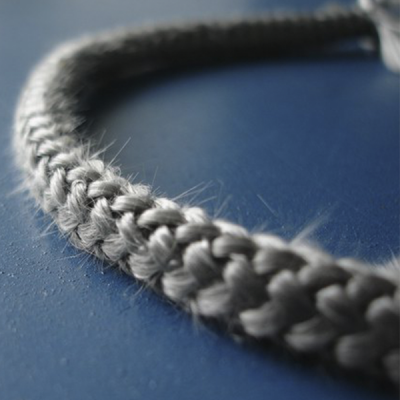 Corda trançada cinzenta sobre superfície azul