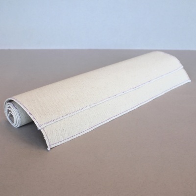 Tapete creme enrolado sobre superfície castanha clara