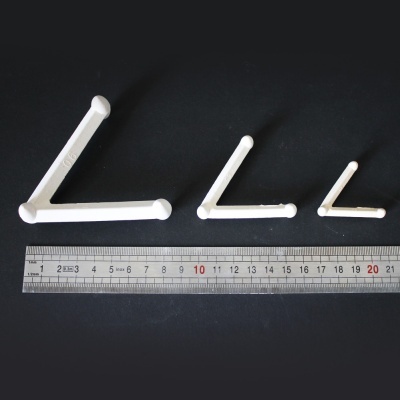 Suportes ou ganchos brancos de plástico em três tamanhos diferentes com régua metálica para medir