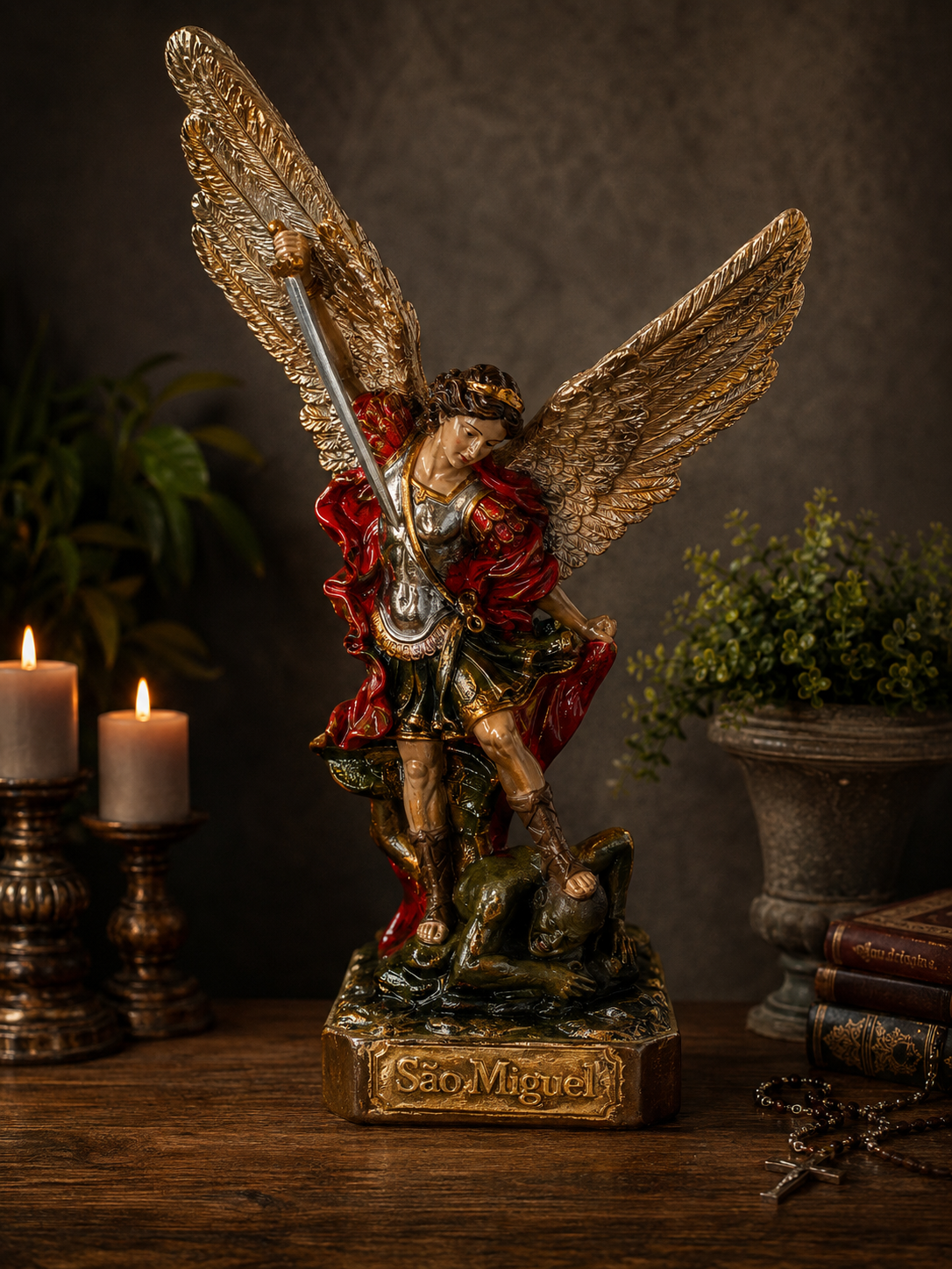 Imagem Gesso S. Miguel Arcanjo 23x8cm Estátua colorida de São Miguel Arcanjo com asas douradas e espada em mesa de madeira com velas, plantas e livros