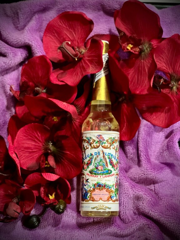 Colonia Agua Florida Original 270ml ? Peru Frasco de bebida Agua de Florida entre flores vermelhas num tecido roxo