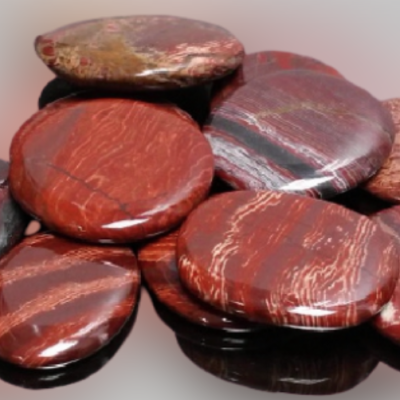 Pedras polidas redondas e achatadas em tons vermelhos e castanhos