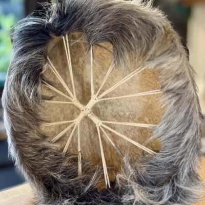 Capacete artesanal com pelo cinzento e estrutura de madeira branca