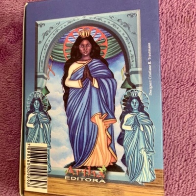 Capa de livro com figura feminina coroada em traje azul e amarelo, duas figuras ao lado, texto Arte Editora e código de barras