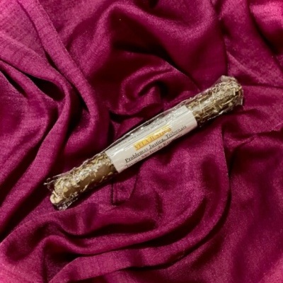 Vela de ervas seca com etiqueta sobre tecido de veludo rosa escuro