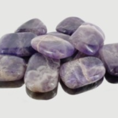 Pedras lisas polidas em tons roxo e branco sobre fundo branco