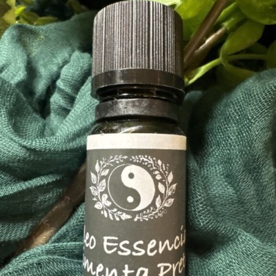 Frasco de óleo essencial com etiqueta preta e símbolo yin-yang