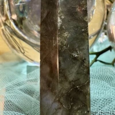 Cristal de quartzo fumado em forma de obelisco sobre tecido azul claro