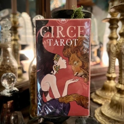 Caixa vermelha com cartas de tarot Circe Tarot e ilustração de mulher e leão