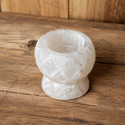 Vaso pequeno decorativo em cristal branco sobre mesa de madeira