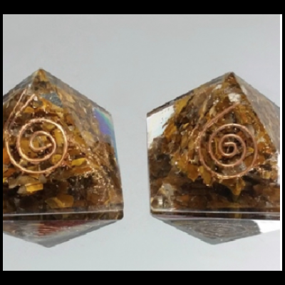 Dois objetos piramidais de resina translúcida com inclusões douradas e espiral de cobre