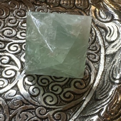 Cristal verde octaédrico sobre prato metálico decorativo