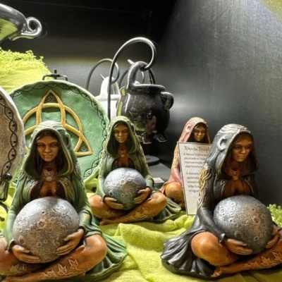 Figuras femininas segurando esferas tipo Lua em tecido verde