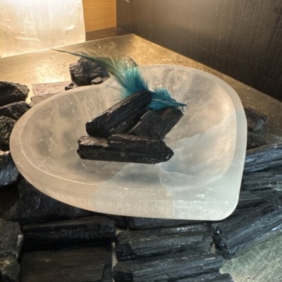 Prato transparente em forma de coração com carvão e pena azul