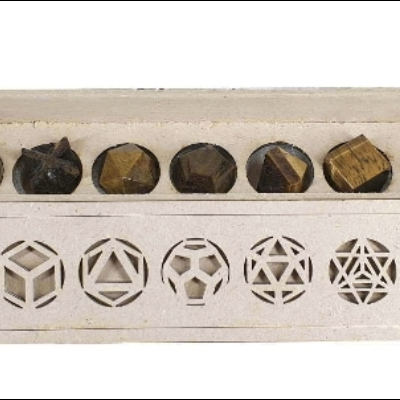 Conjunto de sete pedras polidas castanhas em caixa de madeira com recortes geométricos