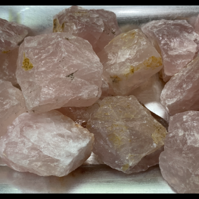 Pedras brutas de quartzo rosa numa bandeja metálica prateada