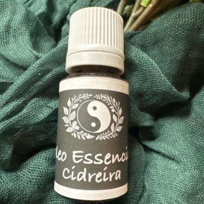 Frasco de óleo essencial cidreira sobre tecido verde
