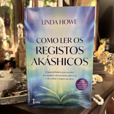 Livro Como Ler os Registos Akáshicos de Linda Howe sobre mesa com decorações
