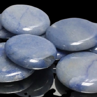 Pedras redondas polidas azul claro com veios em superfície preta