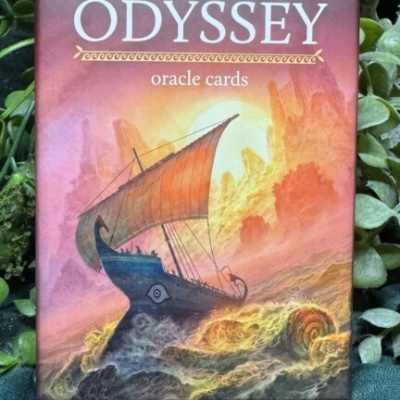 Caixa de cartas oráculo Odyssey com ilustração de barco em águas turbulentas em fundo alaranjado