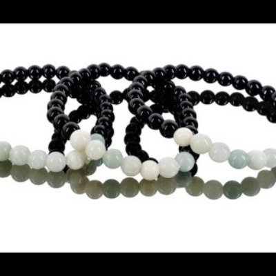 Três pulseiras de contas pretas com contas brancas e verdes claras