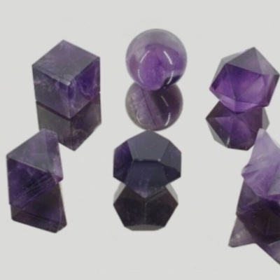 Pedras preciosas violetas em diferentes formas geométricas sobre fundo branco