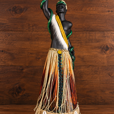 Estátua decorativa de homem com cobra verde e saia de tecido com búzios