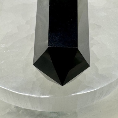 Objeto preto hexagonal pontiagudo sobre superfície cinzenta