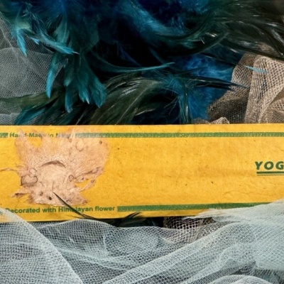 Caixa amarela de incenso Yoga com flor decorativa e tecido de rede branca com plumas azuis