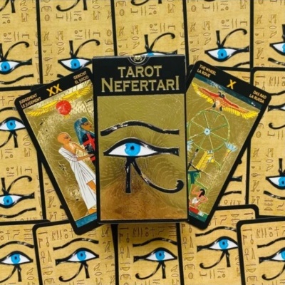 Baralho de tarot TAROT NEFERTARI com cartas douradas e preto exibindo o olho azul e outras imagens.