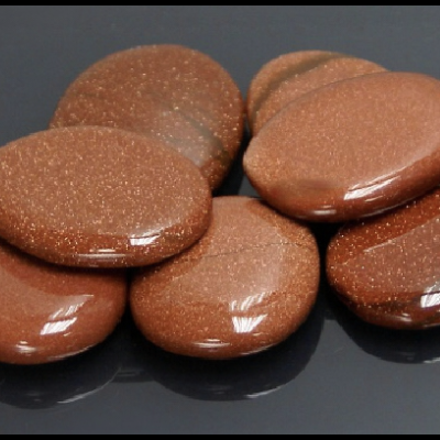 Pedras polidas castanho-dourado brilhantes sobre superfície preta