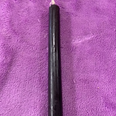 Vela preta sobre pano roxo