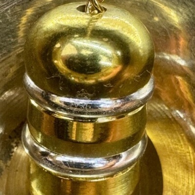 Fecho metálico dourado com detalhes prateados e corrente retorcida