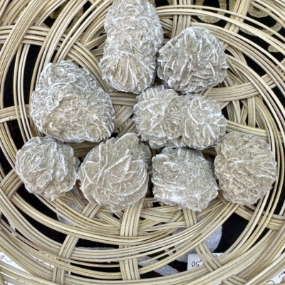Cristais de selenite em forma de folhas numa cesta de vime circular