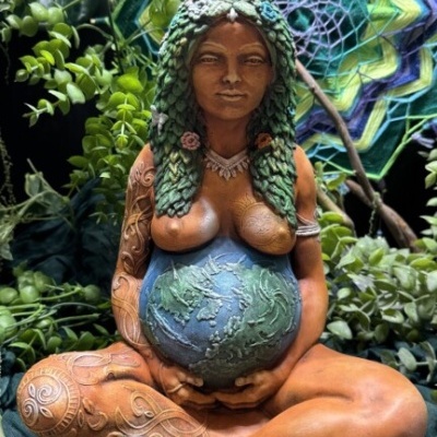 Estátua de mulher grávida com globo terrestre e cabelo verde trançado