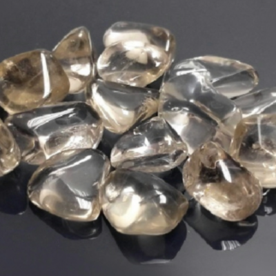 Pedras decorativas transparentes e fumadas polidas sobre fundo escuro
