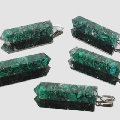 Cinco pendentes de pedra verde em forma de prisma hexagonal com fecho prateado sobre fundo branco