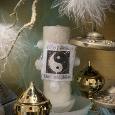 Vela branca de sete mechas com etiqueta yin-yang e incensários dourados