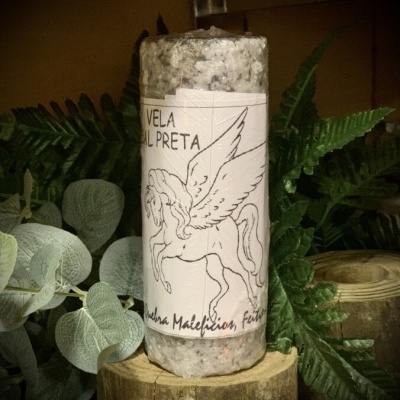 Vela cinza com etiqueta de cavalo alado e texto em português, sobre tronco de madeira com plantas ao fundo
