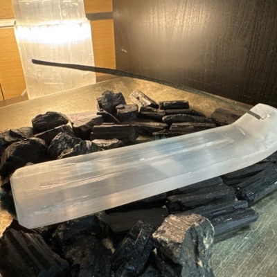 Suporte para incenso em selenite branca com carvão preto e bastão de incenso aceso