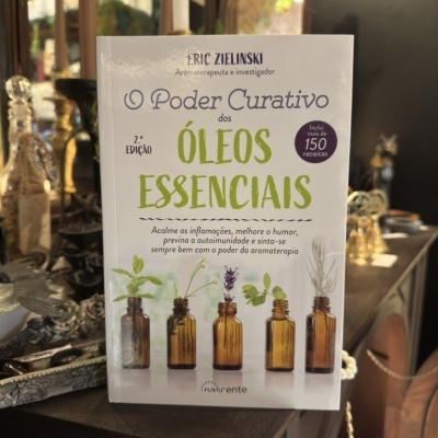 Livro O Poder Curativo dos Óleos Essenciais com imagens de frascos âmbar e plantas.