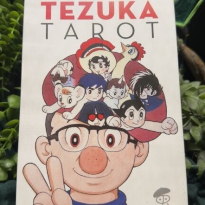 Baralho de tarot Tezuka Tarot com personagens coloridos ilustrados na capa